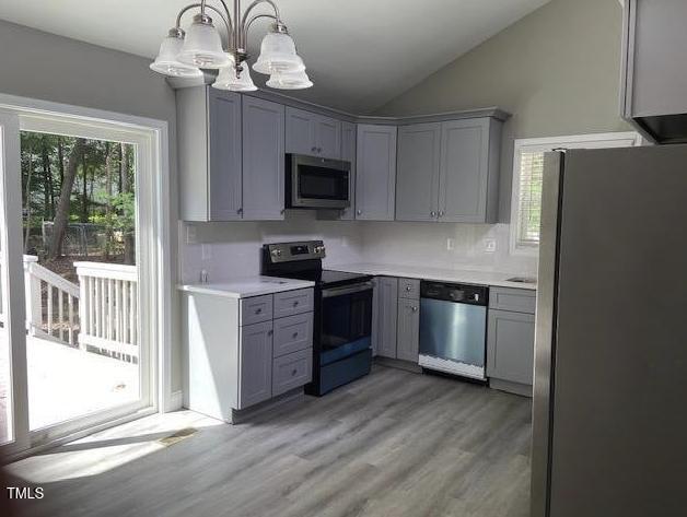 kitchen featuring a chandelier, gray cabinets, stainless steel appliances, and a wealth of natural light