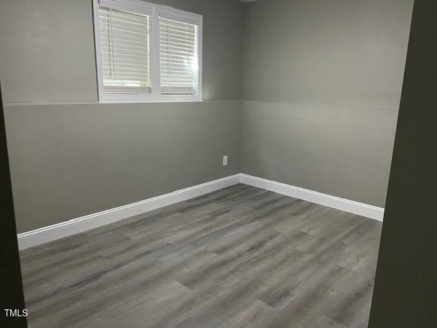 empty room featuring baseboards and wood finished floors