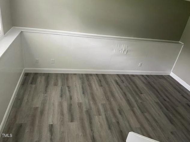 spare room with wood finished floors and baseboards