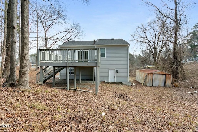 rear view of house featuring a deck, an outdoor structure, stairway, and a shed