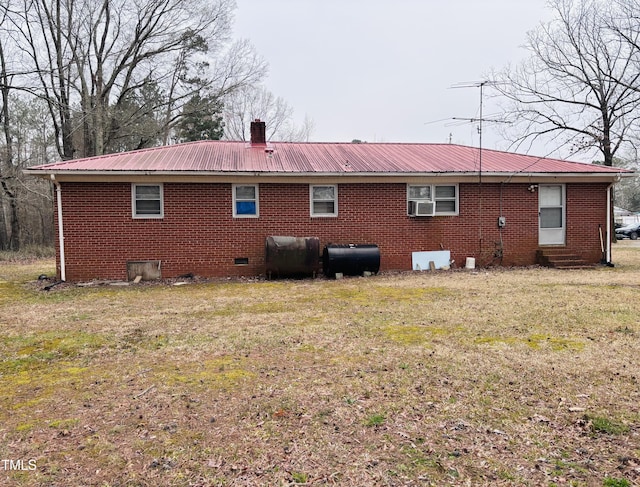 rear view of house with crawl space, a lawn, metal roof, and heating fuel