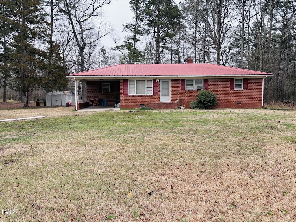 ranch-style home with a front lawn, a carport, metal roof, brick siding, and a chimney