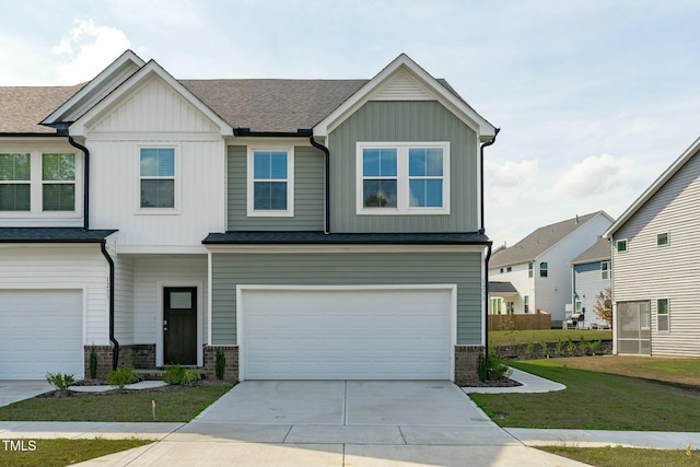 view of front of home featuring a garage, board and batten siding, concrete driveway, and a front lawn