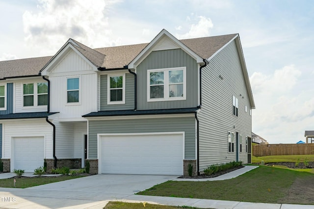 view of front of home with concrete driveway, an attached garage, fence, and board and batten siding