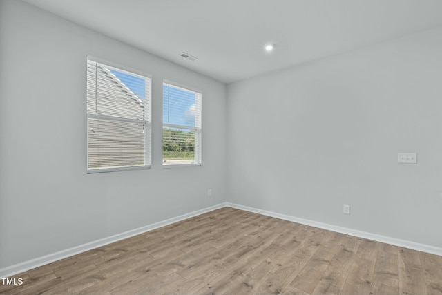 unfurnished room with visible vents, recessed lighting, light wood-type flooring, and baseboards