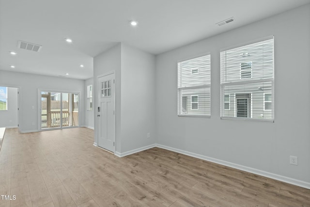 empty room featuring light wood-style flooring, recessed lighting, visible vents, and baseboards