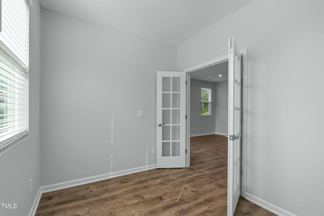 unfurnished room with dark wood-type flooring, french doors, and baseboards