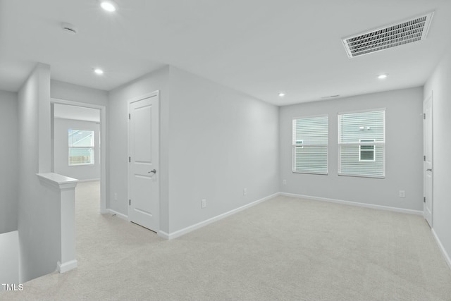 spare room featuring visible vents, recessed lighting, light colored carpet, and baseboards