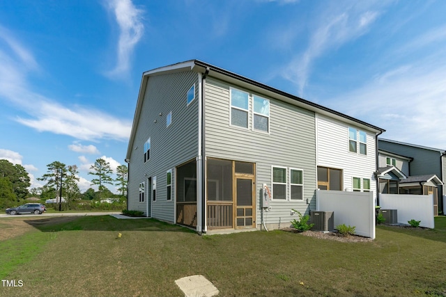 back of property featuring central air condition unit, a sunroom, a yard, and fence