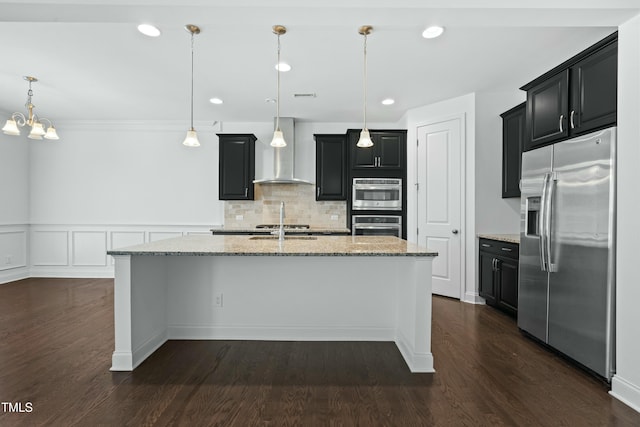 kitchen with dark wood finished floors, wall chimney range hood, stainless steel refrigerator with ice dispenser, and dark cabinets