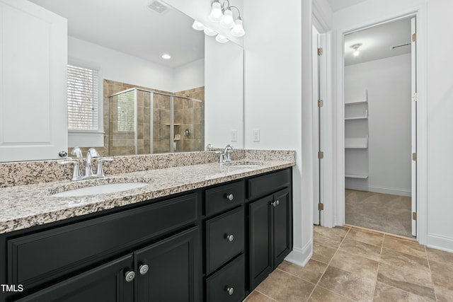 full bath with double vanity, a stall shower, visible vents, and a sink