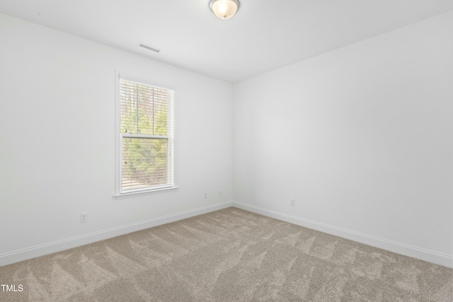 carpeted empty room with visible vents and baseboards