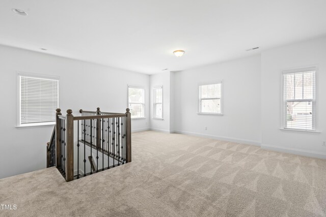 unfurnished room featuring visible vents, baseboards, and carpet