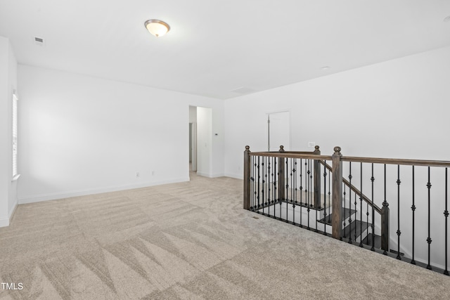 carpeted empty room with visible vents and baseboards