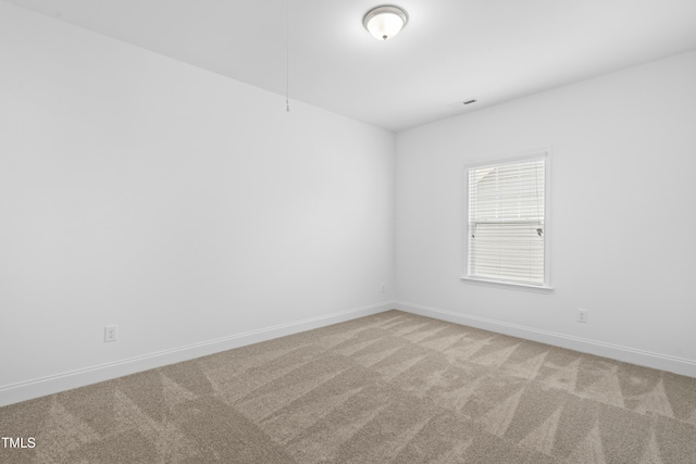 carpeted spare room featuring visible vents and baseboards