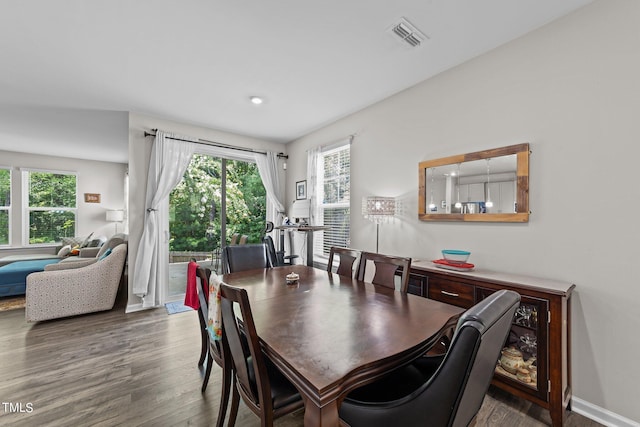 dining area featuring wood finished floors, visible vents, and baseboards