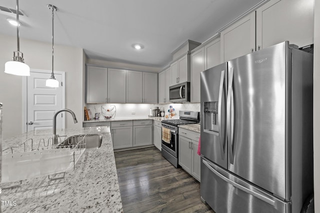 kitchen featuring dark wood-style floors, stainless steel appliances, tasteful backsplash, and a sink