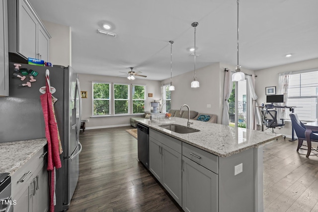 kitchen with a sink, open floor plan, stainless steel appliances, ceiling fan, and dark wood-style flooring