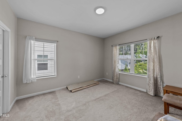 carpeted spare room featuring baseboards