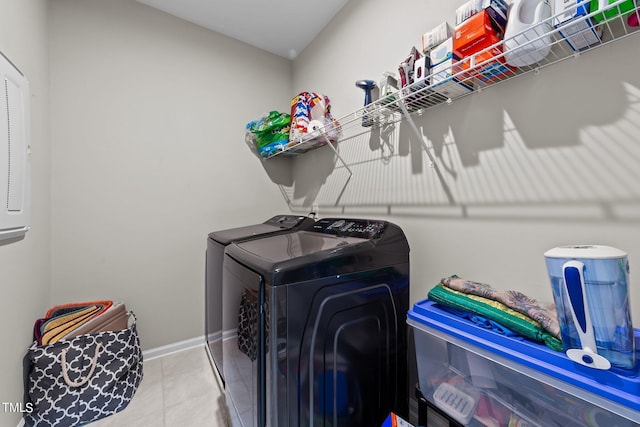 clothes washing area with tile patterned flooring, laundry area, independent washer and dryer, and baseboards