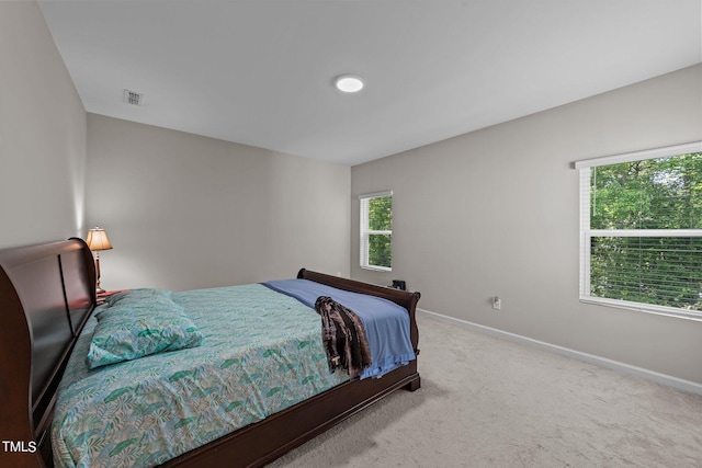 bedroom featuring visible vents, multiple windows, baseboards, and carpet floors