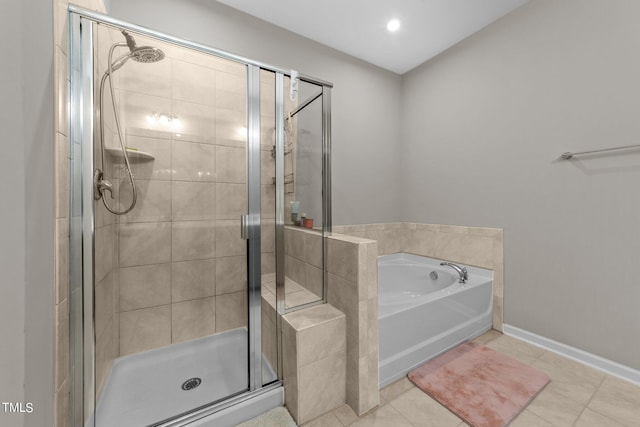 bathroom featuring tile patterned flooring, a shower stall, baseboards, and a garden tub