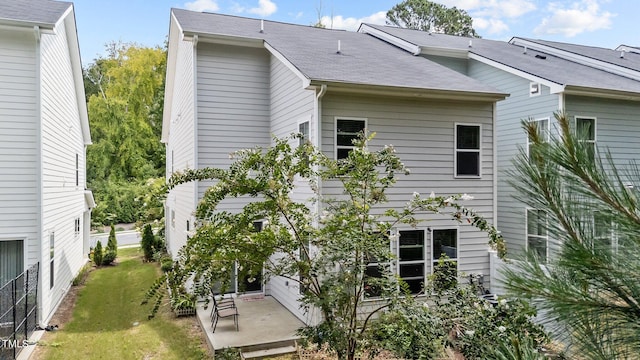 back of property with a patio and a lawn