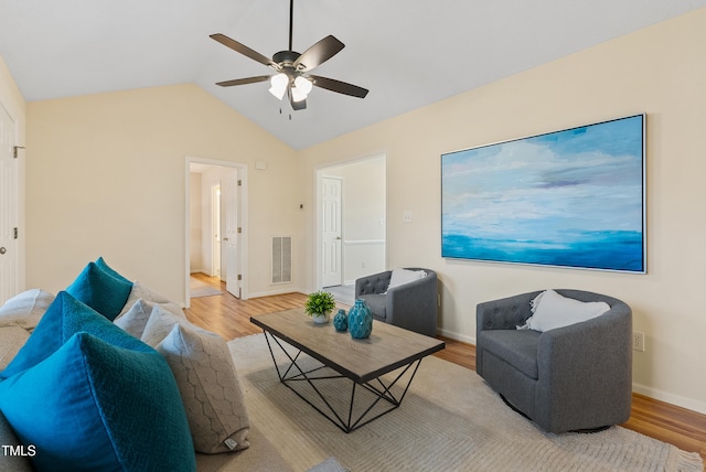 living area featuring visible vents, lofted ceiling, a ceiling fan, and wood finished floors