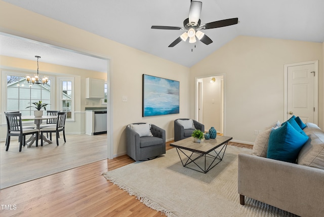 living room with ceiling fan with notable chandelier, baseboards, light wood-style flooring, and lofted ceiling