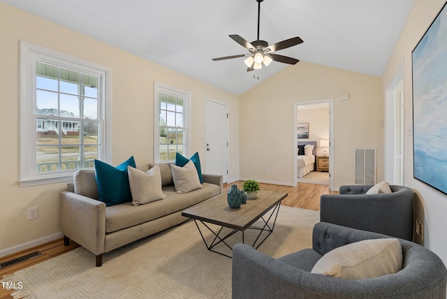 living area with vaulted ceiling, visible vents, a ceiling fan, and wood finished floors