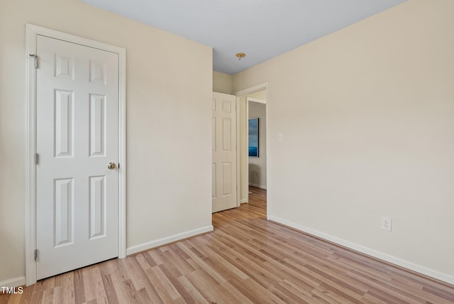 unfurnished bedroom featuring baseboards and light wood-style flooring