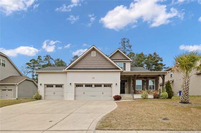 craftsman inspired home featuring concrete driveway, a garage, and a front lawn