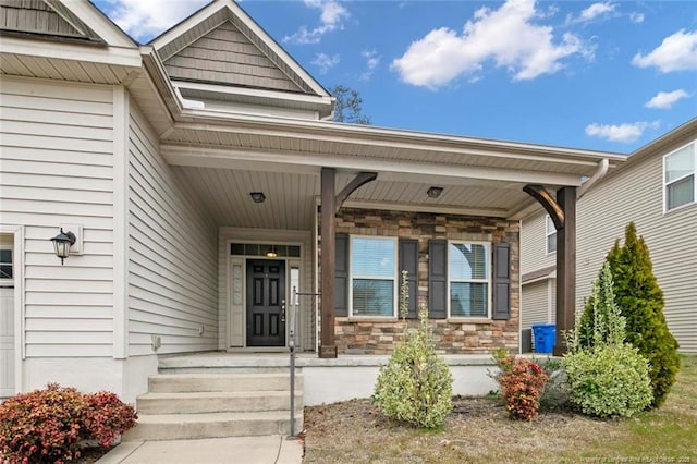 property entrance with a porch and stone siding