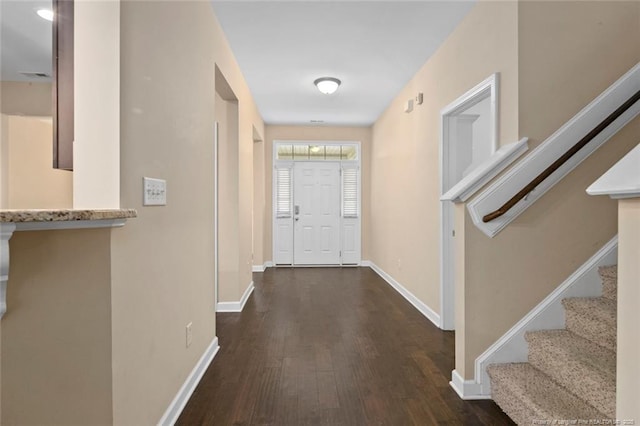 foyer with stairway, baseboards, and wood finished floors