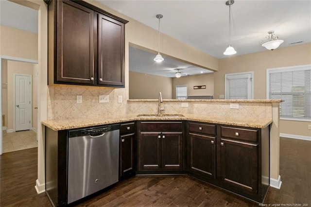 kitchen featuring a sink, tasteful backsplash, stainless steel dishwasher, dark brown cabinetry, and a peninsula