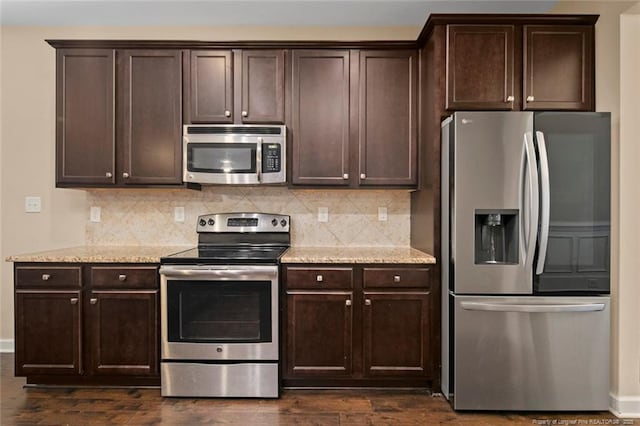 kitchen featuring stainless steel appliances, dark brown cabinetry, dark wood-style floors, and decorative backsplash