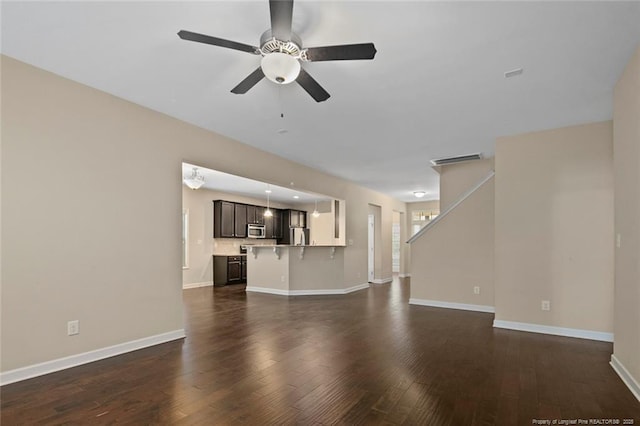 unfurnished living room featuring visible vents, baseboards, dark wood-type flooring, and ceiling fan