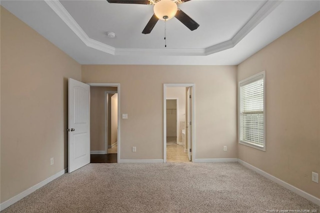 unfurnished bedroom with carpet flooring, baseboards, and a tray ceiling