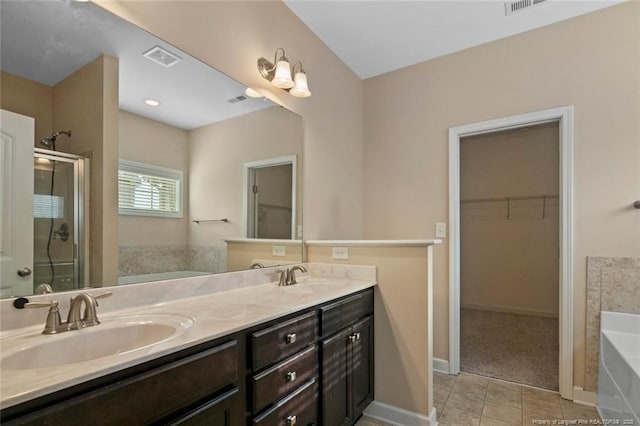 bathroom featuring double vanity, a stall shower, a bath, and a sink