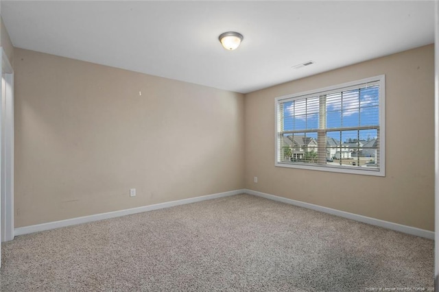 empty room featuring baseboards, visible vents, and carpet floors