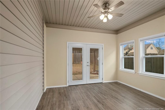 unfurnished sunroom featuring french doors, wooden ceiling, and a ceiling fan