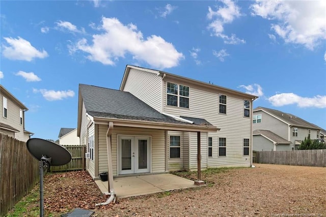 back of property featuring french doors, a patio, roof with shingles, and a fenced backyard