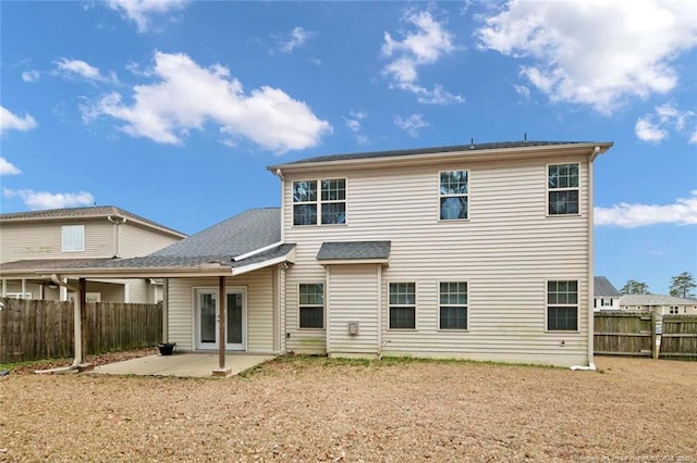 rear view of property featuring french doors, a patio, and fence