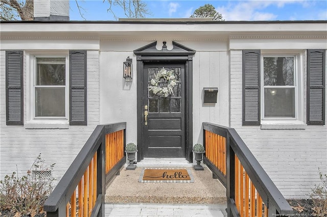 entrance to property with brick siding and a chimney