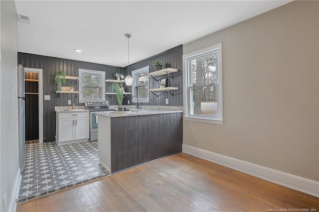 kitchen featuring a wealth of natural light, electric range, baseboards, and open shelves