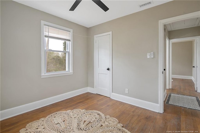 bedroom with visible vents, baseboards, attic access, and wood finished floors