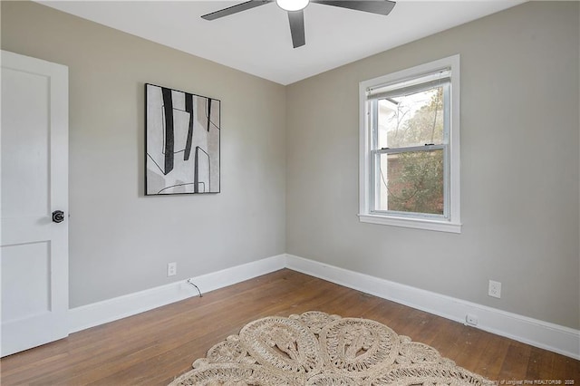 empty room featuring wood finished floors, baseboards, and ceiling fan