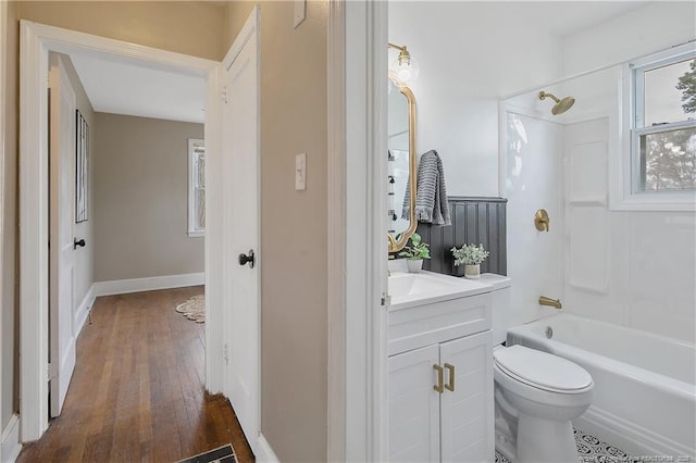 bathroom featuring vanity, wood finished floors, toilet, and tub / shower combination