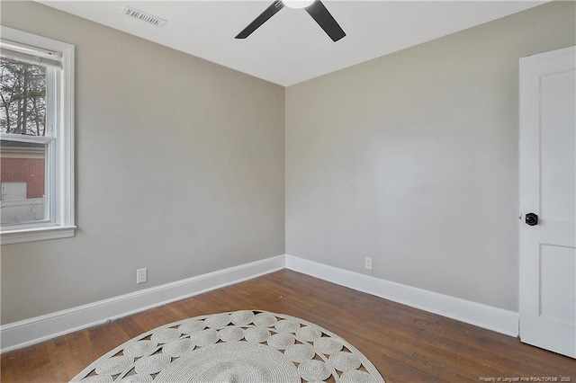 empty room with wood finished floors, visible vents, baseboards, and ceiling fan