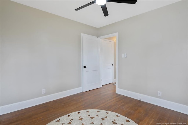 unfurnished room with wood finished floors, a ceiling fan, and baseboards